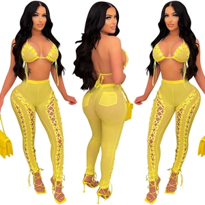 Detail of yellow mesh two-piece set featuring lace-up hollow out sides and high waist trousers