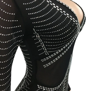 Detailed view of shimmering silver rhinestones on sheer black mesh party dress fabric