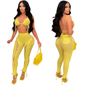 Detail of yellow mesh see-through two-piece set featuring cutout lace-up trousers