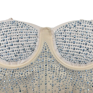 Detail of sheer mesh panel and silver rhinestones on a beige mesh party dress