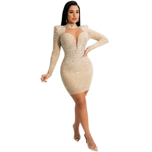 Détails de broderie en perles de cristal et strass sur la robe courte en tulle beige