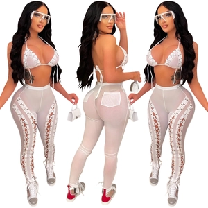 Detail of white mesh two-piece set featuring lace-up bikini top and sheer hollow-out trousers