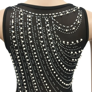 Detail of sheer black mesh dress featuring elegant faux pearls and sparkling rhinestones