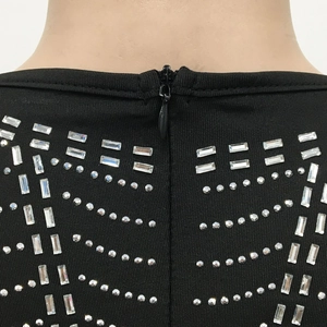 Detail of the back hidden zipper and rhinestone wave pattern on a mesh black dress