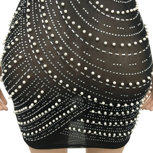 Close-up of black mesh mini dress featuring flowing wave patterns of white pearls and rhinestones