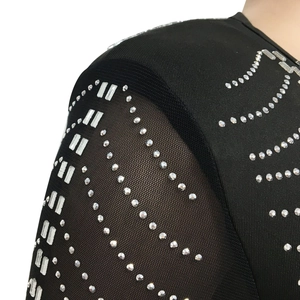 Detail of sheer black mesh sleeves with elegant white rhinestone patterns on dress
