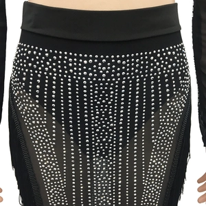 Detail of high-waist black skirt with rhinestones and long fringe for party wear