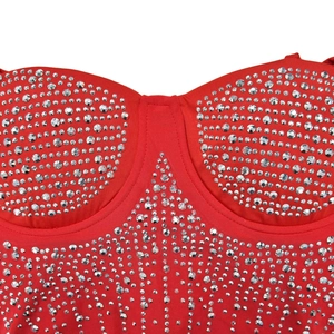 Close-up of sparkling silver rhinestones on a vibrant red mesh party dress bodice