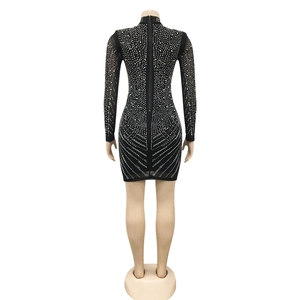 Détail du dos d'une robe noire à manches longues avec strass et fermeture éclair