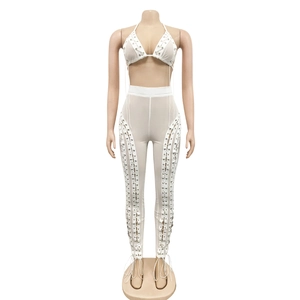 Close-up of sexy white two-piece set featuring lace-up details and silver metal eyelets