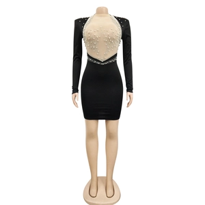 Close-up of black bodycon dress with sheer mesh panel and white pearl embellishments