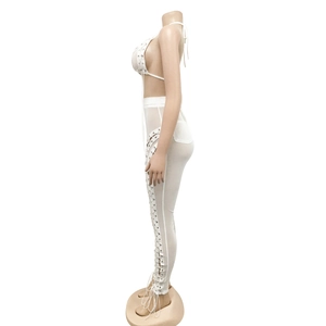 Detail view of the side lace-up design on a white mesh sleeveless top and pants set