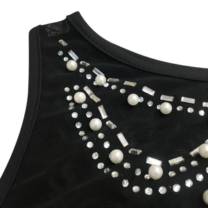 Close-up of neckline with rhinestones and faux pearls on black mesh mini dress