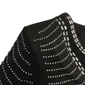 Detailed close-up of sparkling silver rhinestones on black mesh fabric evening dress