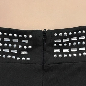 Detailed view of the black camisole showing rhinestone geometric patterns and zipper