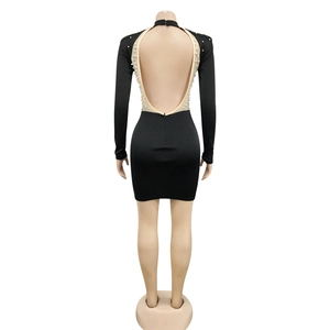 Detail of sexy backless black mini dress featuring white pearls and beadwork on the back
