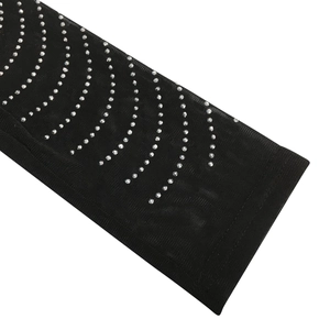 Detail of sheer black mesh fabric featuring rows of sparkling silver rhinestones