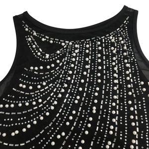 Close-up of black mesh dress neckline with intricate white pearls and rhinestones