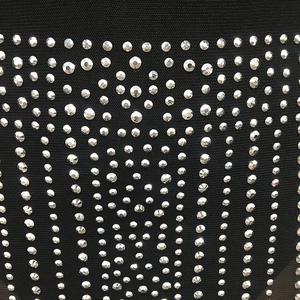 Macro shot of sparkling silver rhinestones on black mesh fabric detail for dresses