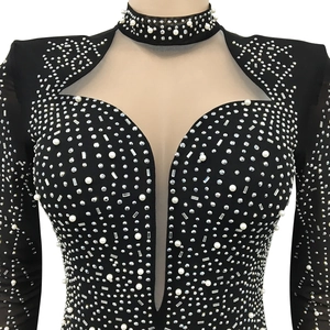 Détail de robe de soirée noire ornée de perles et de strass brillants sur résille transparente