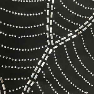Detail of black knit dress with rhinestone spider web pattern and crystal embellishments