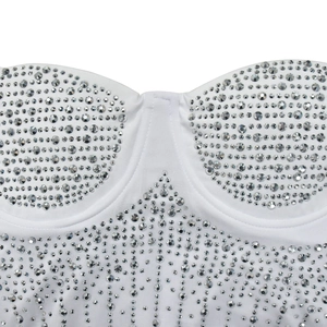 Macro detail of silver rhinestones on a white mesh party dress with sweetheart neckline