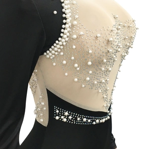 Detail of sheer mesh dress featuring intricate white pearls and iridescent rhinestones