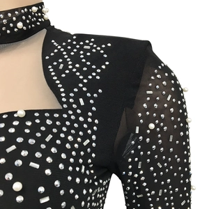 Détail d'une robe de soirée noire en mesh avec perles de luxe et strass brillants