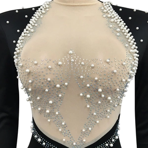 Close-up of mesh dress detailing with intricate white pearls and sparkling rhinestones