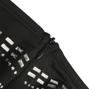 Close-up of invisible zipper and crystal rhinestone detailing on black mesh dress