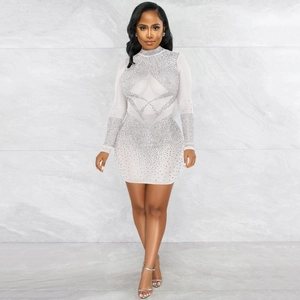 Close-up of white mesh dress featuring shimmering silver rhinestones in geometric patterns