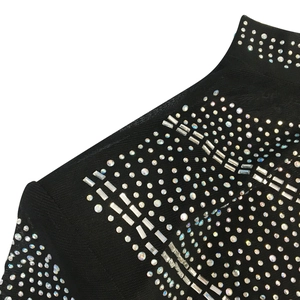 Detail of rhinestones and silver bar embellishments on a black mesh long sleeve dress