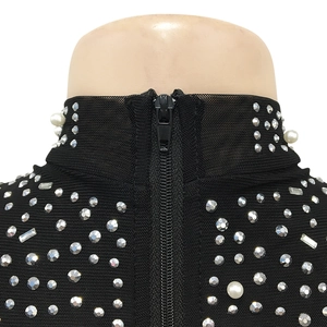 Détail du col en résille noire orné de strass brillants et de perles blanches