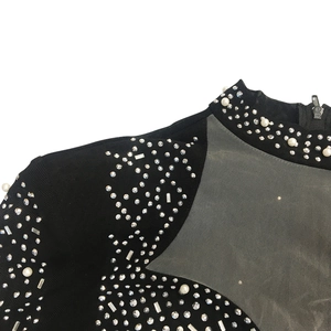 Détail de l'encolure en mesh transparent avec perles et strass sur robe noire