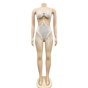Détail d'un body blanc à paillettes avec des franges et un design ajouré à la taille