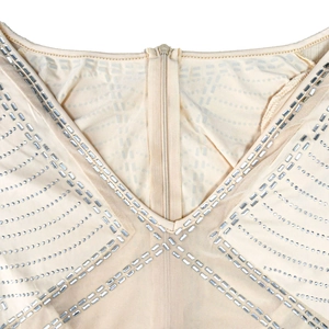 Detailed view of sheer mesh dress featuring silver rhinestones and a V-neck zip closure