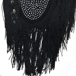 Detail of black mesh dress featuring shimmering rhinestones and long fringe tassels