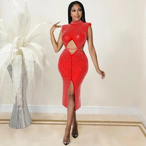 Détail de la robe en résille rouge ornée de strass brillants avec fente latérale