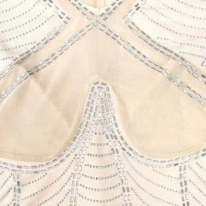 Close-up of sheer mesh fabric with silver sequins and geometric rhinestone patterns