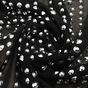 Detailed macro shot of black mesh fabric with sparkling silver rhinestones and crystal studs