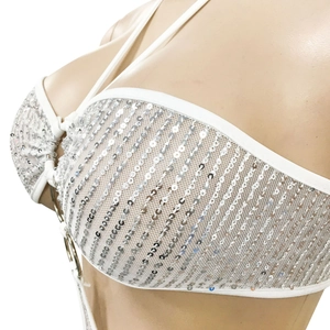 Détail de tissu en maille blanche avec paillettes argentées sur la combinaison