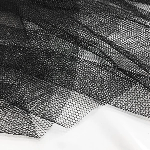 Close-up detail of premium black honeycomb mesh tulle fabric with soft drape