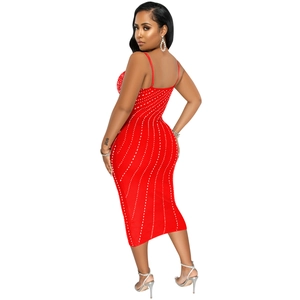 Detailed view of red midi dress with white rhinestone wave patterns and spaghetti straps