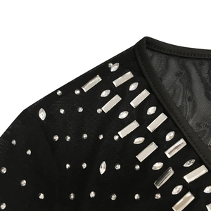 Close-up of black mesh fabric with sparkling crystal rhinestones in various geometric shapes