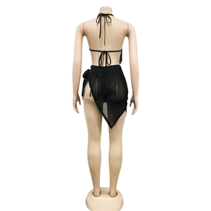 Detail view of black backless halter top and asymmetrical fringe skirt with rhinestones