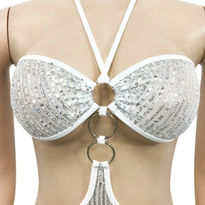 Détail du body blanc à paillettes avec anneaux argentés et texture ondulée élégante