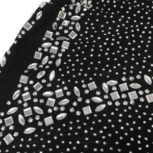 Macro detail of rhinestone patterns on black mesh fabric for sexy evening dress