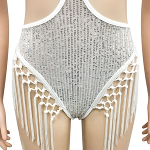 Gros plan d'un body blanc à paillettes montrant des franges perlées et un tissu en maille