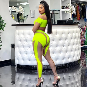 Detail des neongelben Mesh-Jumpsuits mit transparenten Einsätzen und hoher Taille am Modell