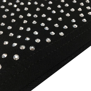 Macro detail of sparkling silver rhinestones on black fabric for an evening dress